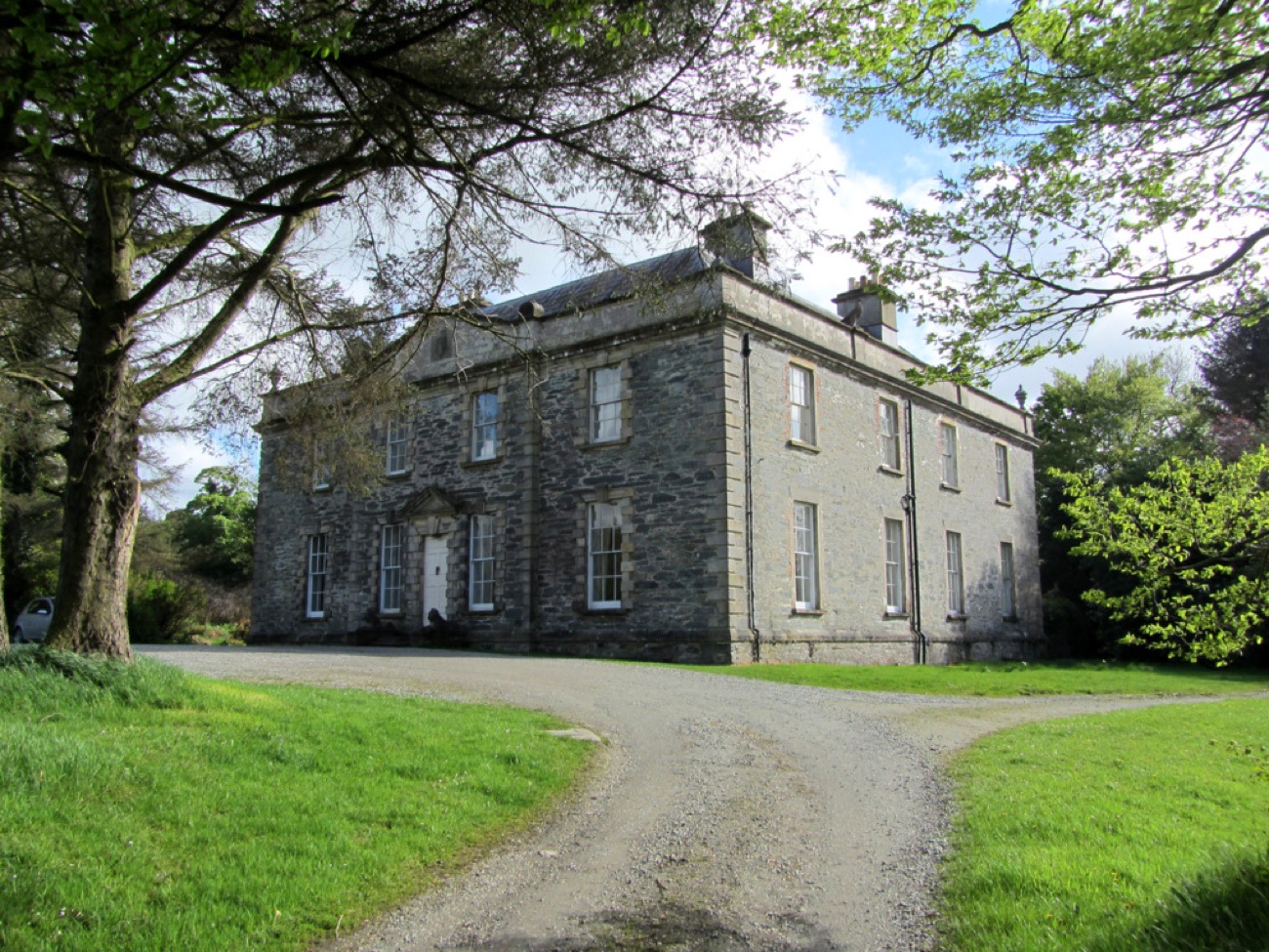 Prehen House framed by mature trees along its wooded drive above the River Foyle