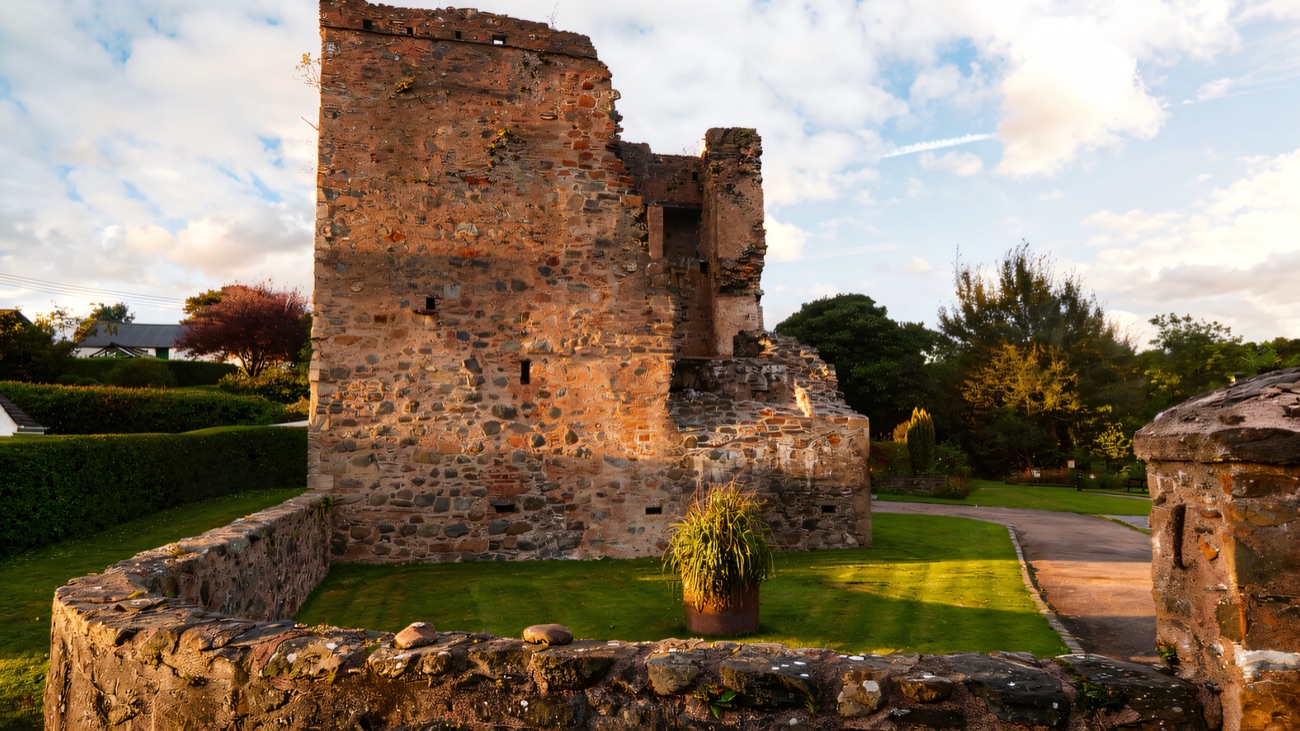 The tower house and its low enclosing wall on a bright day near Downpatrick.