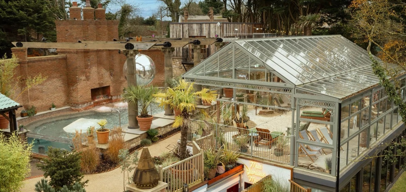 The outdoor spa garden with palms, the Palm House glasshouse and the Roman bath.
