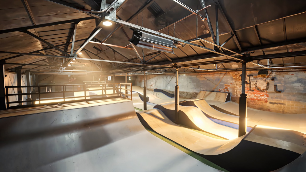 The indoor park with its rollers and ramps under a warehouse roof