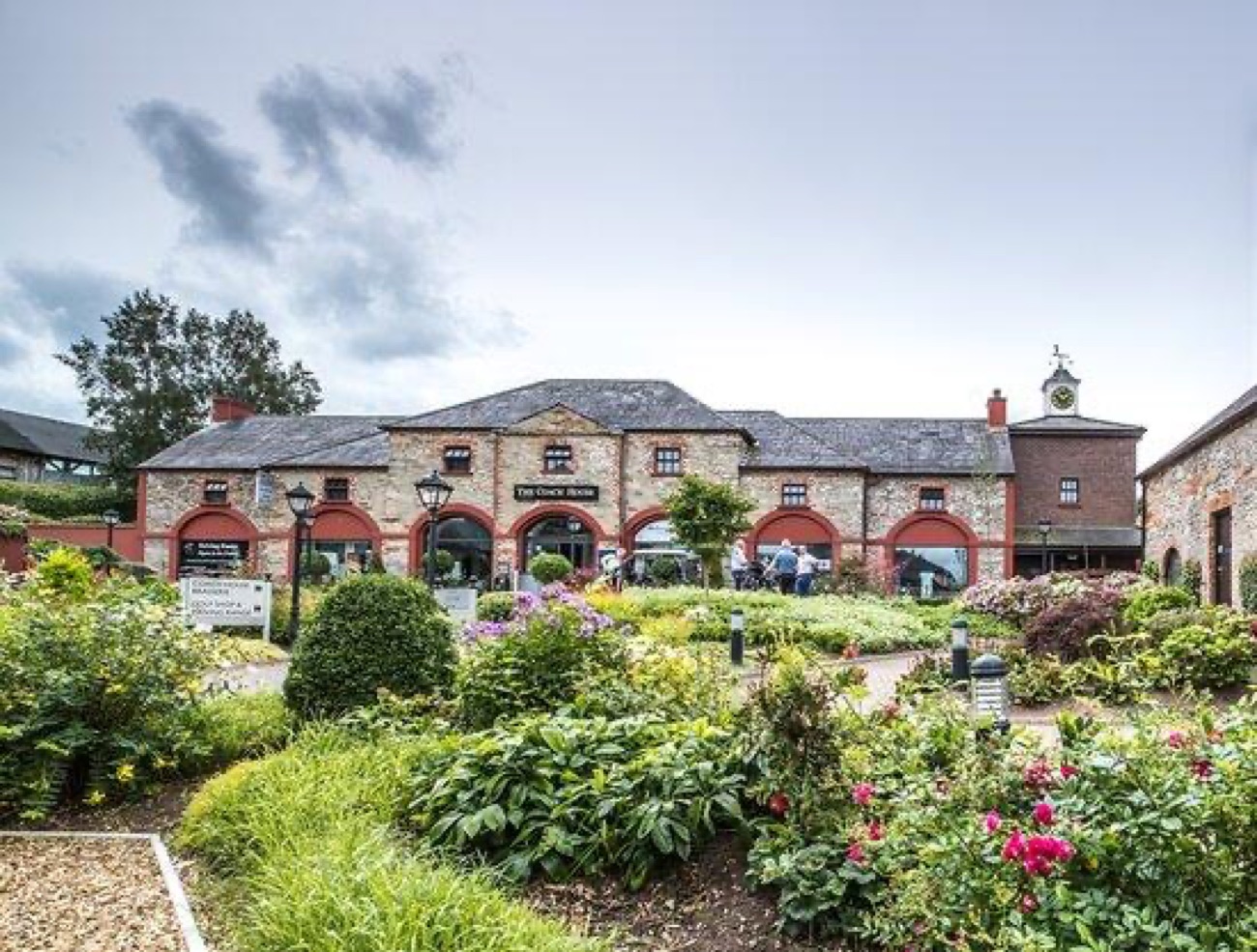 The Coach House brasserie behind flowering gardens in the resort courtyard.