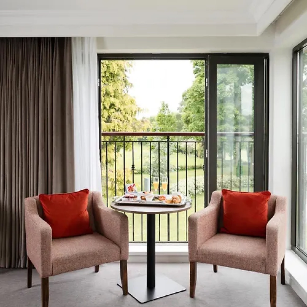 Two soft armchairs by a window looking out over the resort's green grounds.