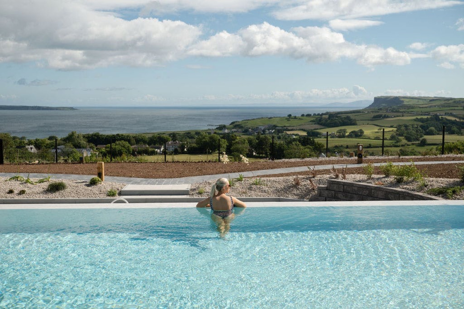 The outdoor infinity pool at Salt Spa, its edge blending into the Atlantic with Fair Head in the distance.