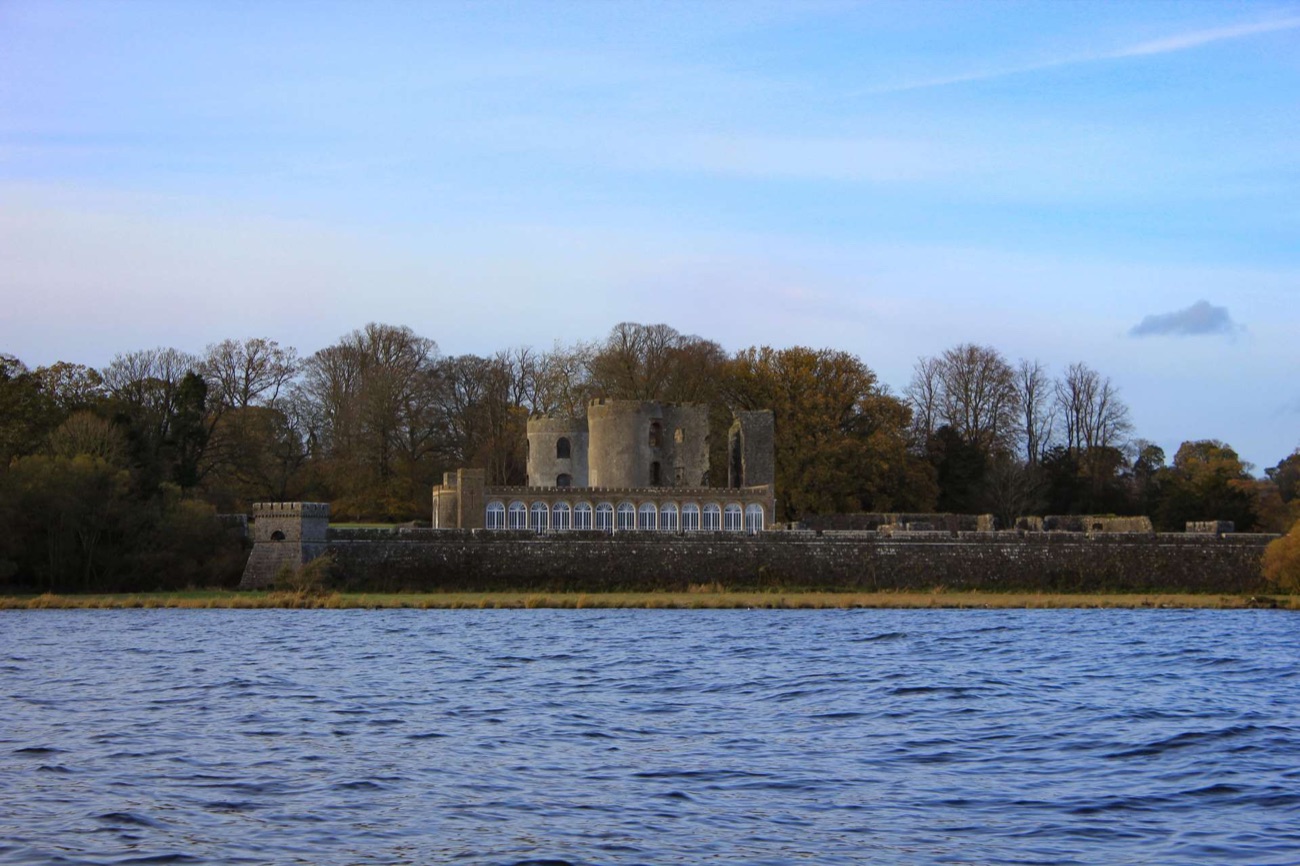 The castle ruins and Camellia House seen across Lough Neagh