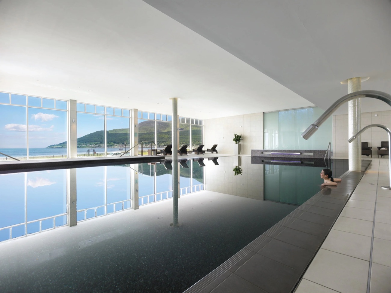 A quiet swim with the beach and Mourne Mountains framed through floor-to-ceiling windows.