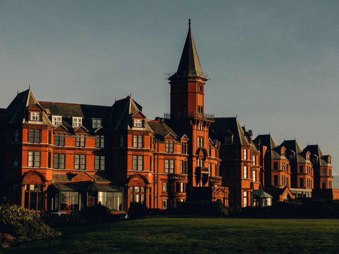 Evening light on the hotel's clock tower and gabled roofline above the seafront.