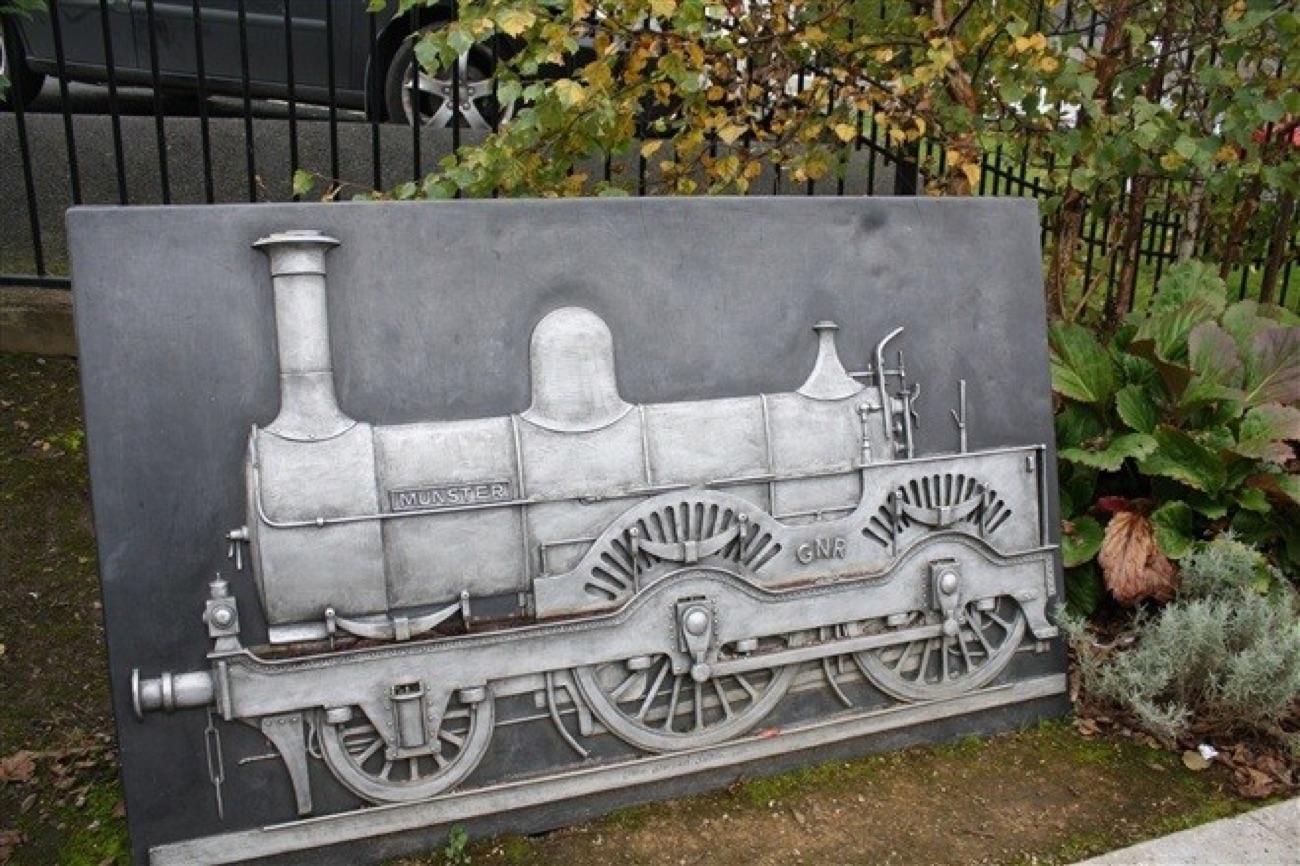 A cast metal relief panel of a Great Northern Railway steam locomotive set into the park