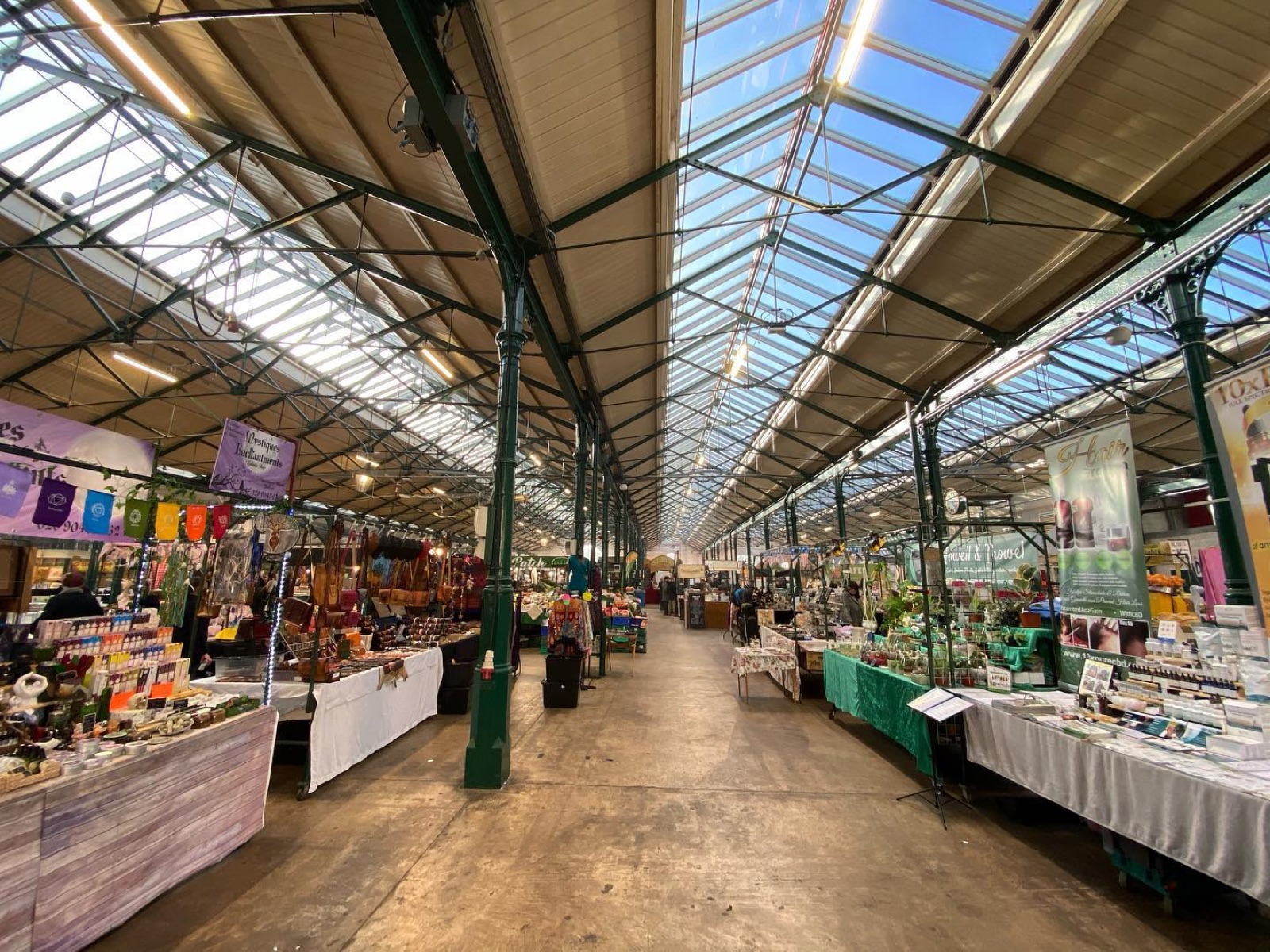 The grand Victorian hall of St George's Market — green iron pillars and a glazed pitched roof running down a long aisle of stalls
