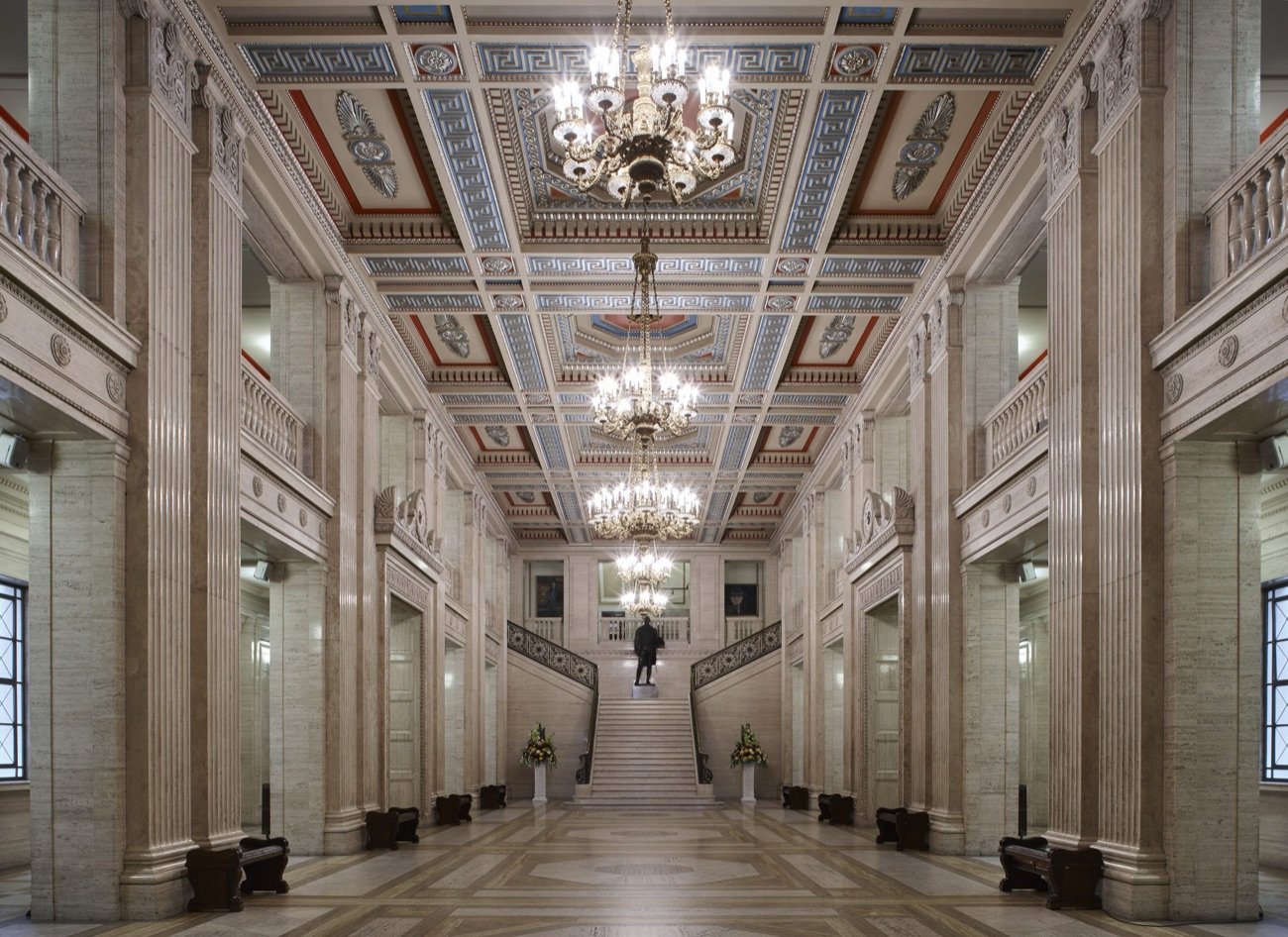 The Great Hall inside Parliament Buildings — marble columns, a painted coffered ceiling and the grand staircase