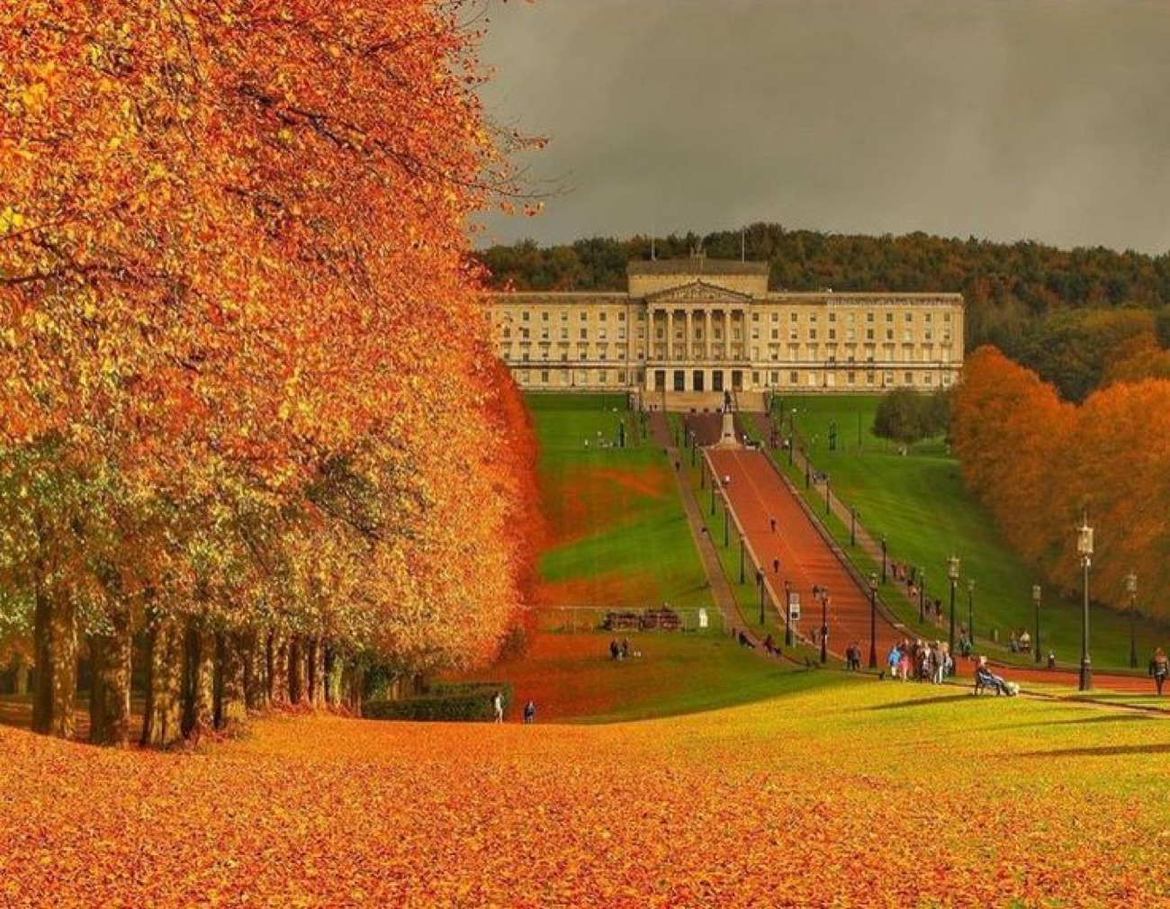 Parliament Buildings across the Stormont estate in autumn, framed by golden trees