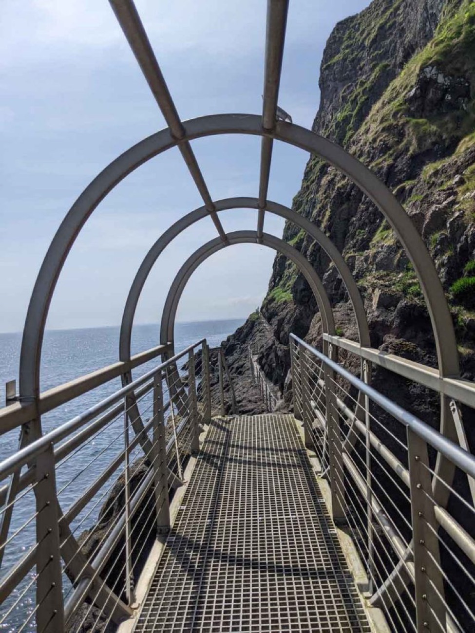 Looking through the arched tubular cage walkway out to the open sea