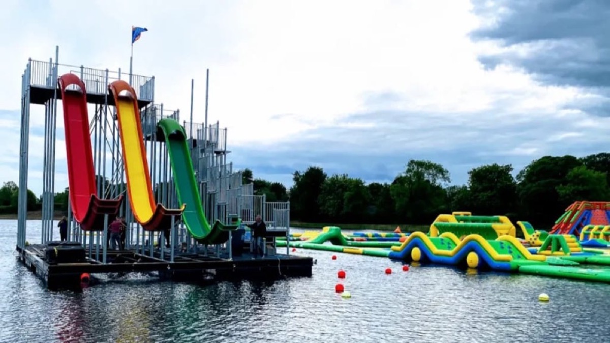 The tall floating slide tower beside the obstacle course