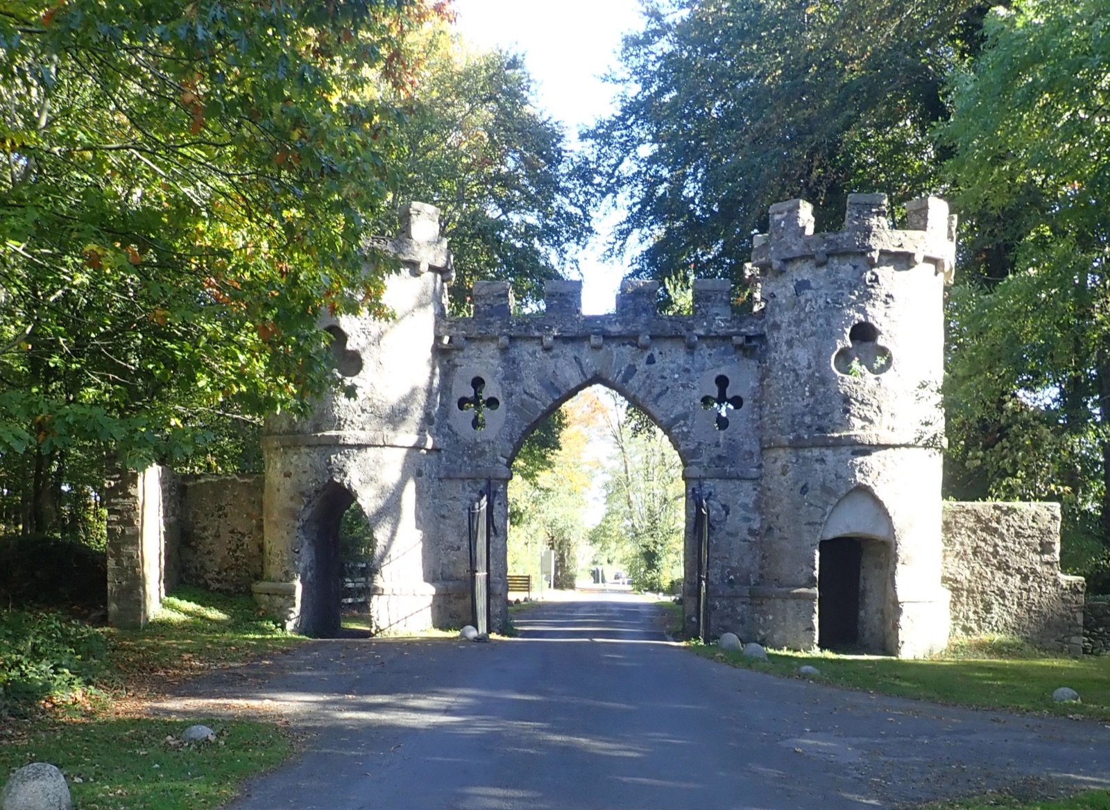 The Barbican — a grey stone castellated gothic gateway arch over the park road, framed by trees