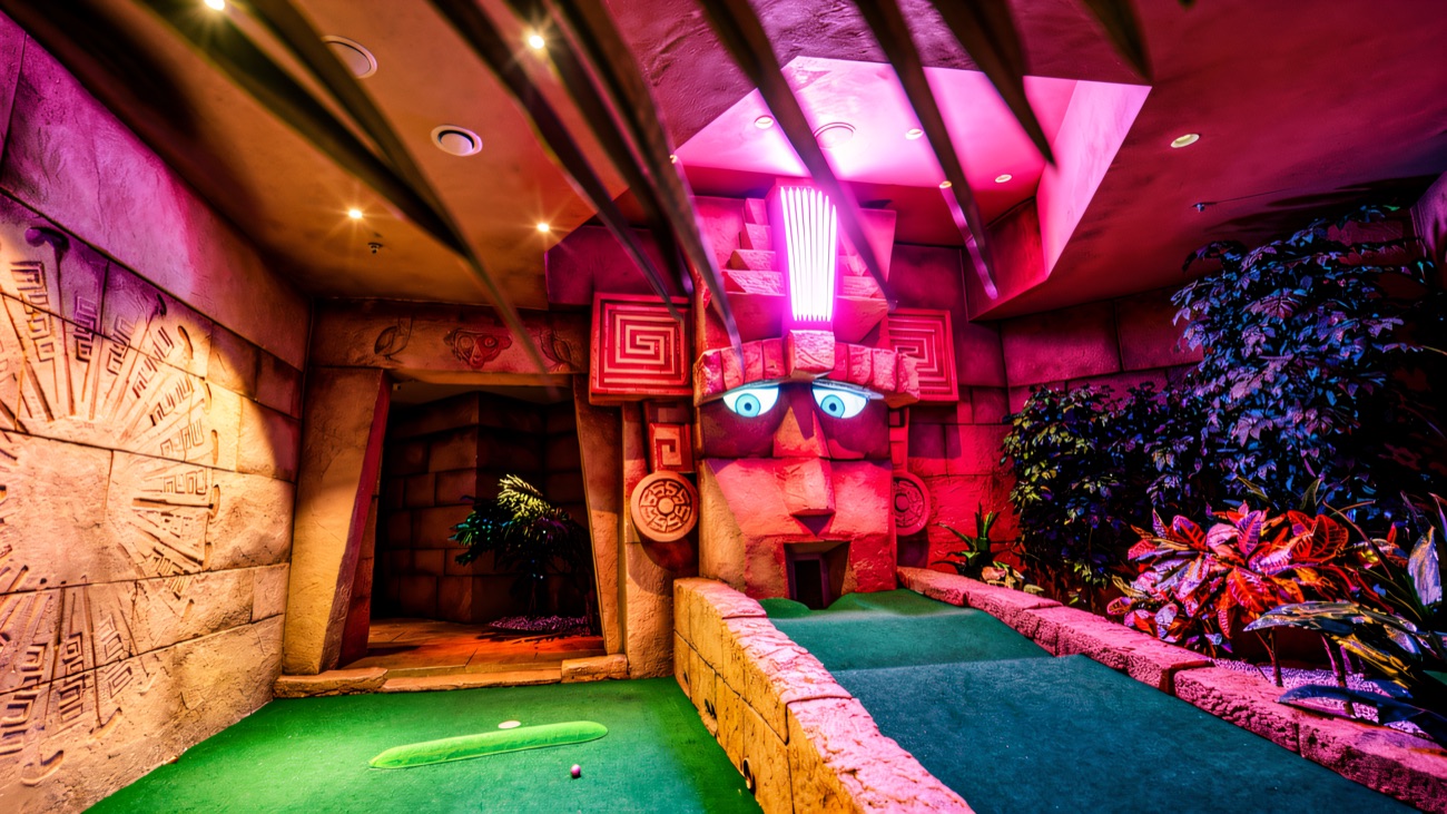 An ancient temple hole carved from stone under moody purple light