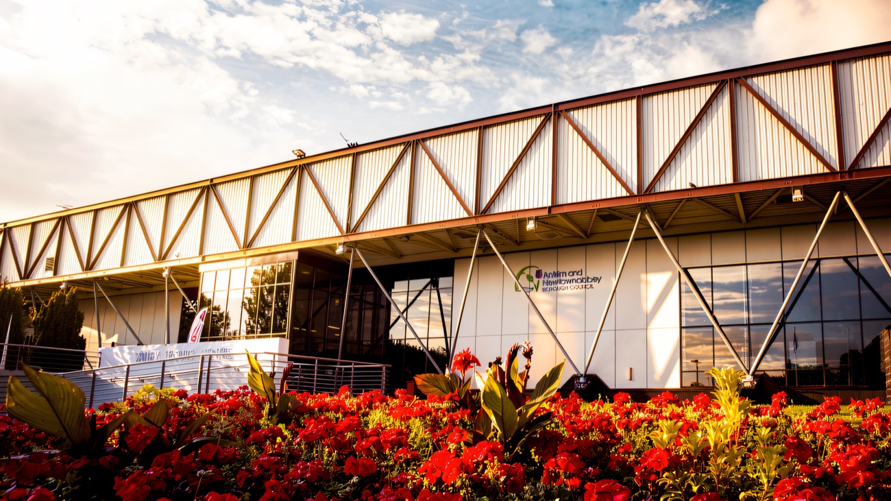 The front of Valley Leisure Centre behind a bed of red flowers