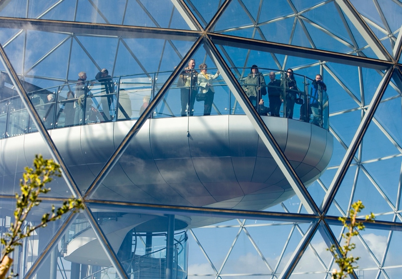 Visitors standing on the viewing gallery inside the glass dome at Victoria Square, high above Belfast