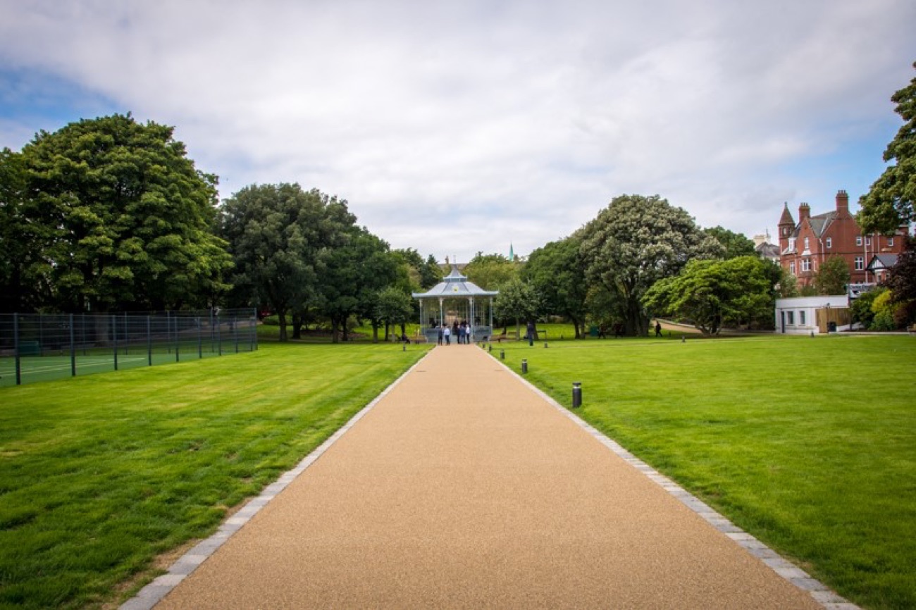 A long lawn and gravel avenue running through Warrenpoint Municipal Park between mature trees