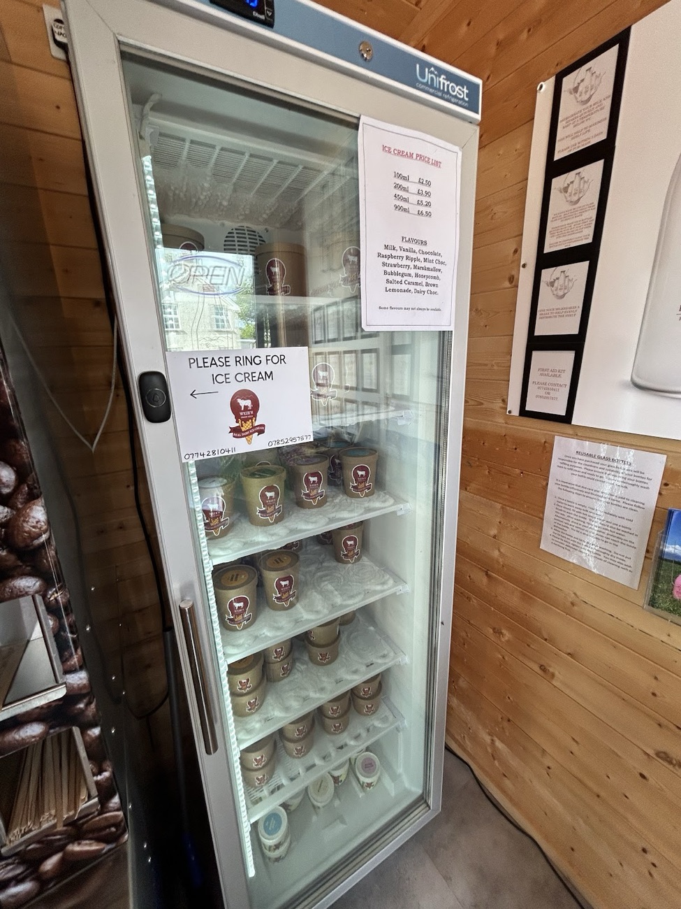 A glass-fronted freezer of farm ice cream tubs inside the cabin